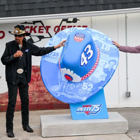 (From left) Speedway Motorsports President and CEO Marcus Smith joins NASCAR Hall of Fame inductee Richard Petty, middle, and NBC Sports Racing Analyst Kyle Petty in unveiling a special Petty hat saluting the family's 75-year history in NASCAR, on Friday at North Wilkesboro Speedway. 